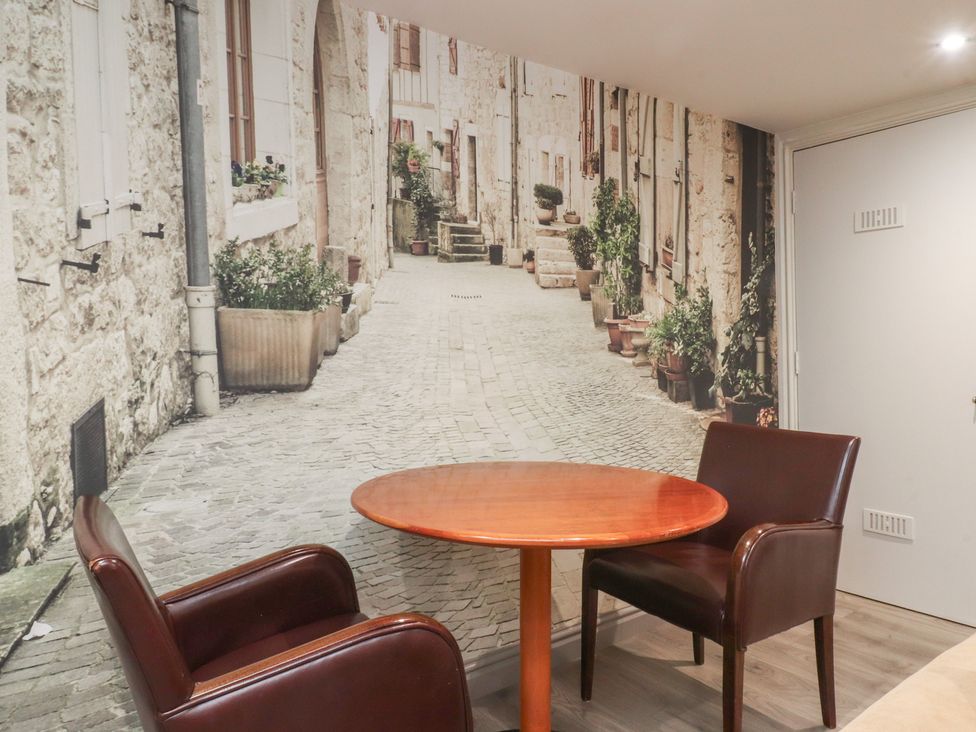 A dining room with a wooden table and chairs at Paramount Apartments in Lytham St. Annes