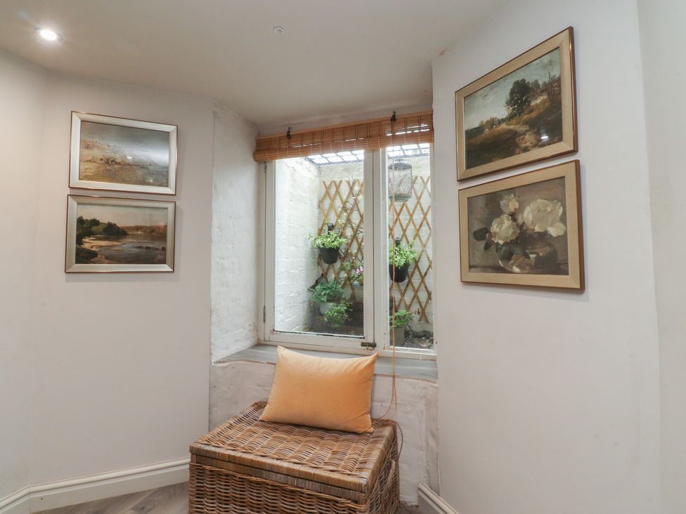 A snug with paintings on the wall and a window with plants at Paramount Apartments in Lytham St. Annes
