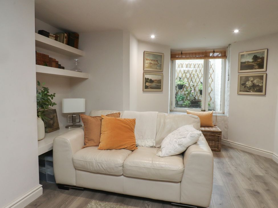 A living room with a sofa and bookshelves at Paramount Apartments in Lytham St. Annes