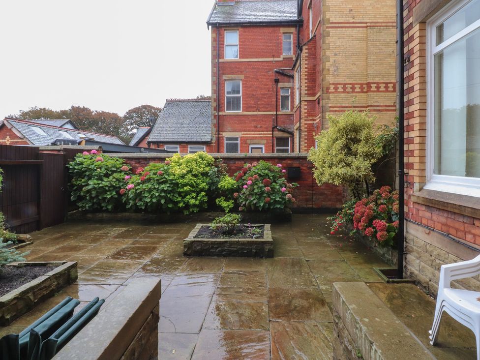 A garden with flowers and a patio area at Paramount Apartments in Lytham St. Annes