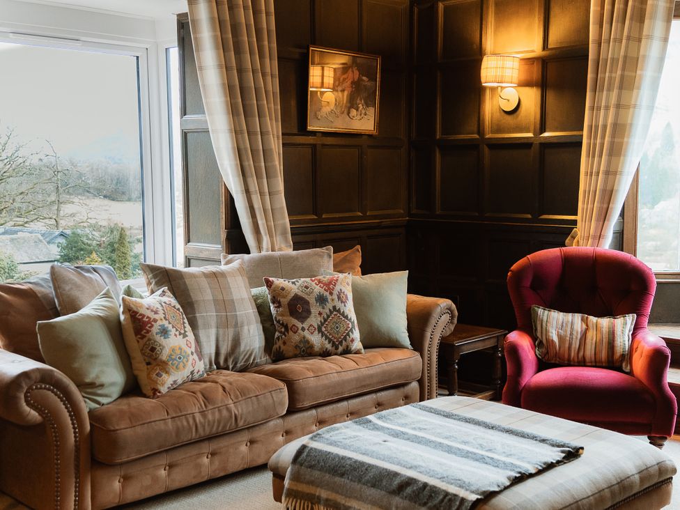A living room with a sofa and armchair at Grey Walls in Glenridding