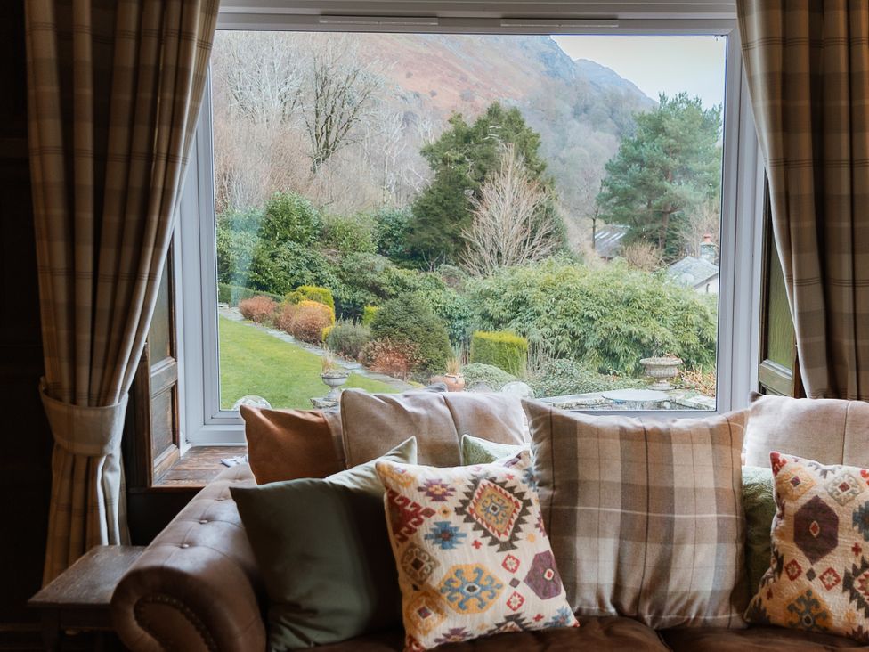 A living room with a view of a garden at Grey Walls in Glenridding