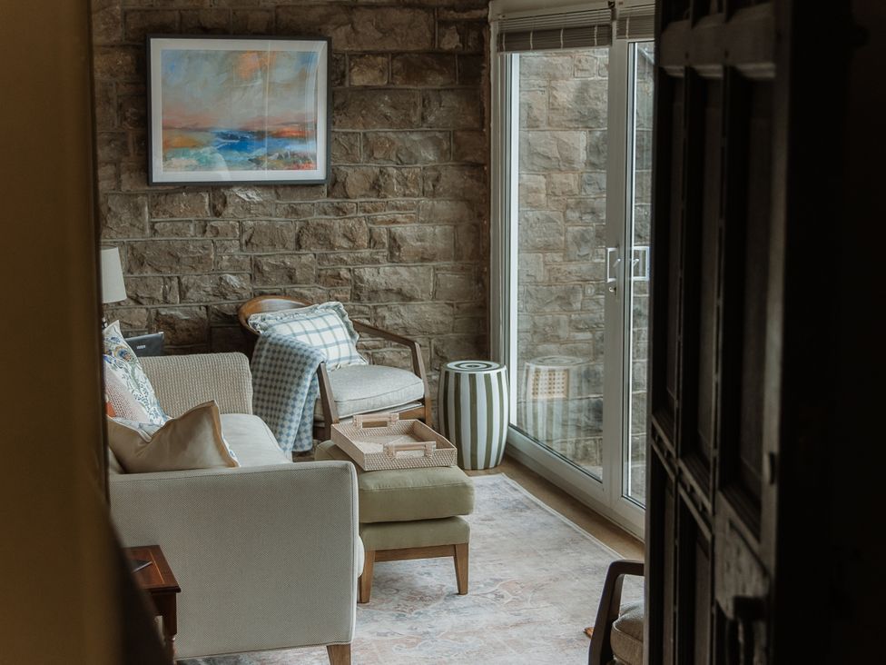 A living room with a sofa and armchair at Grey Walls in Glenridding