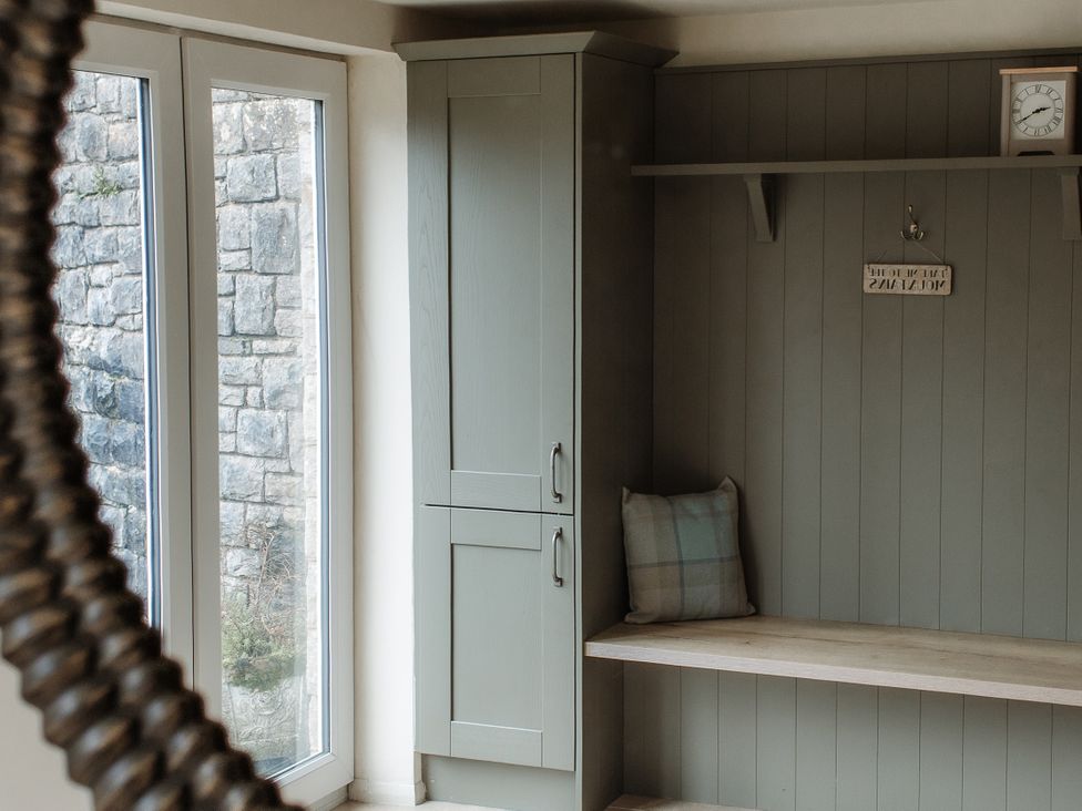 A hallway with a cabinet and shelf at Grey Walls in Glenridding