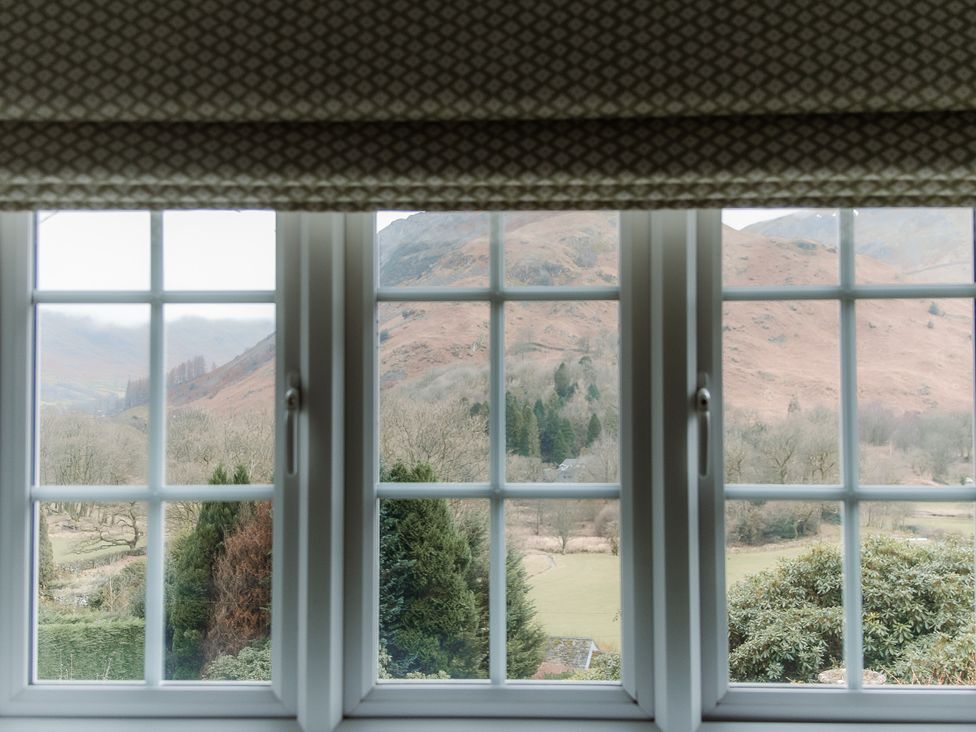 A window view showing mountains and trees at Grey Walls in Glenridding