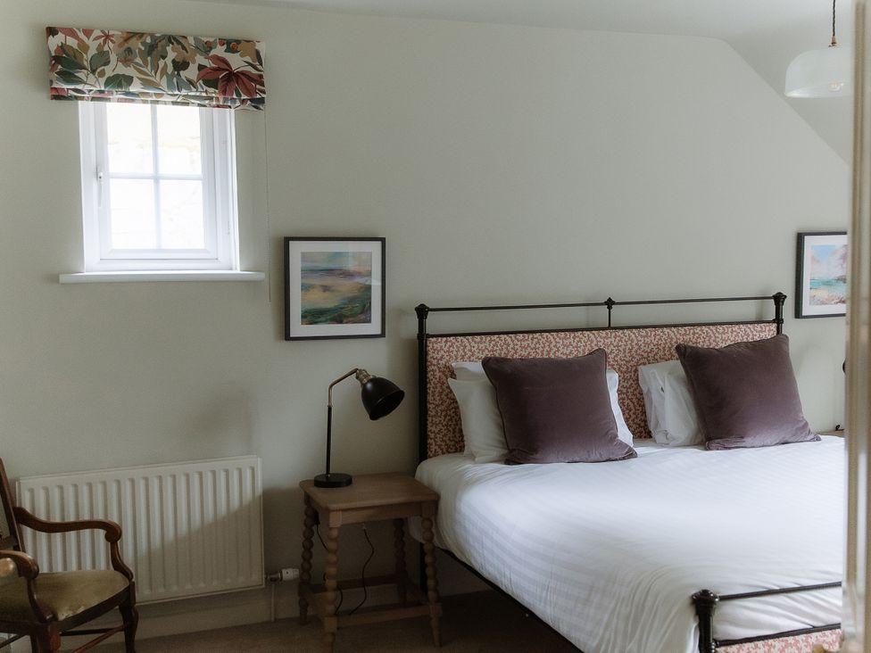 A bedroom with a bed, bedside table, and a window at Grey Walls in Glenridding