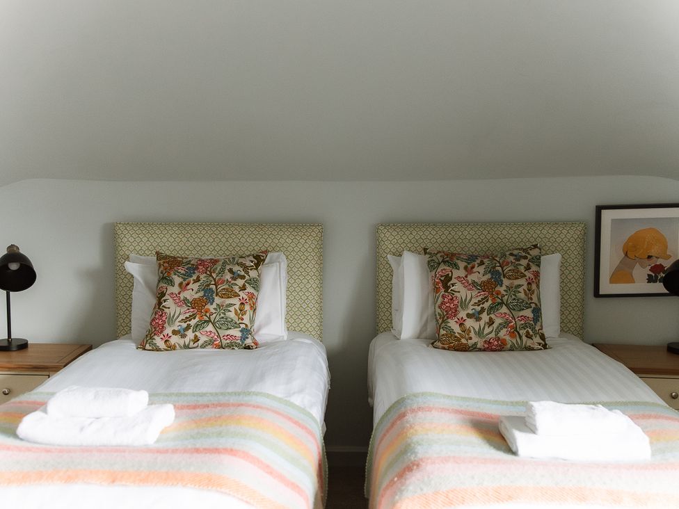 A bedroom with two beds and a lamp at Grey Walls in Glenridding
