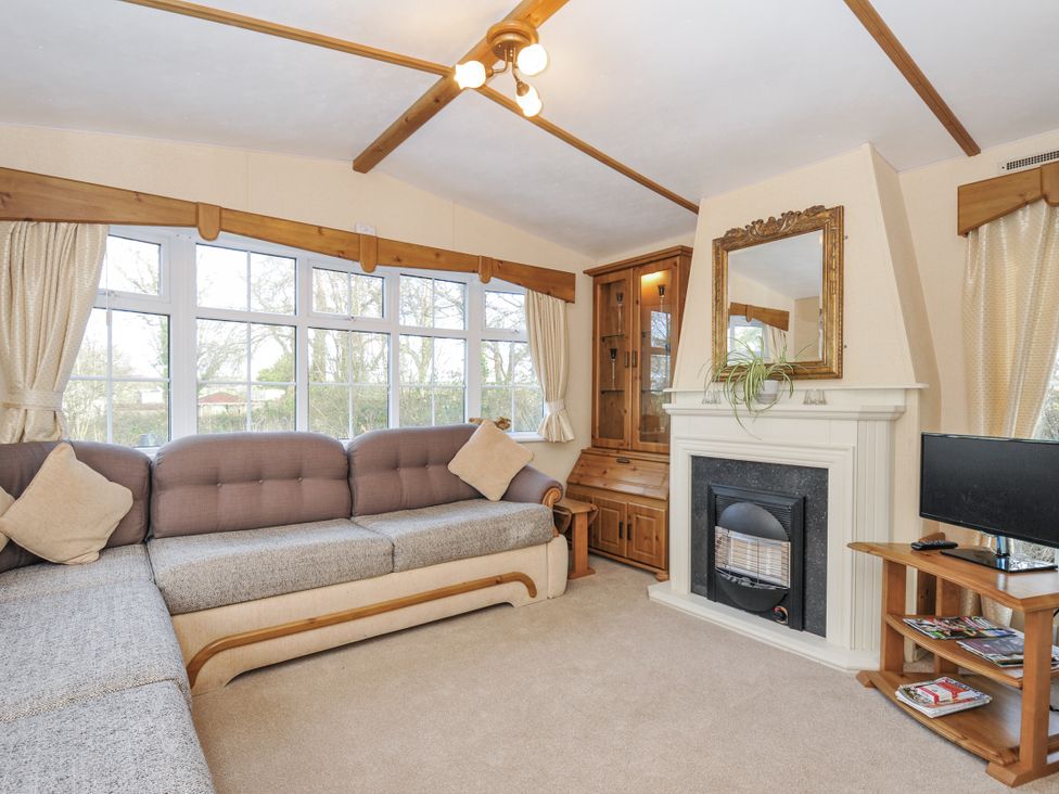 A living room with a sofa, fireplace and television at Little Malory in St Giles-On-The-Heath