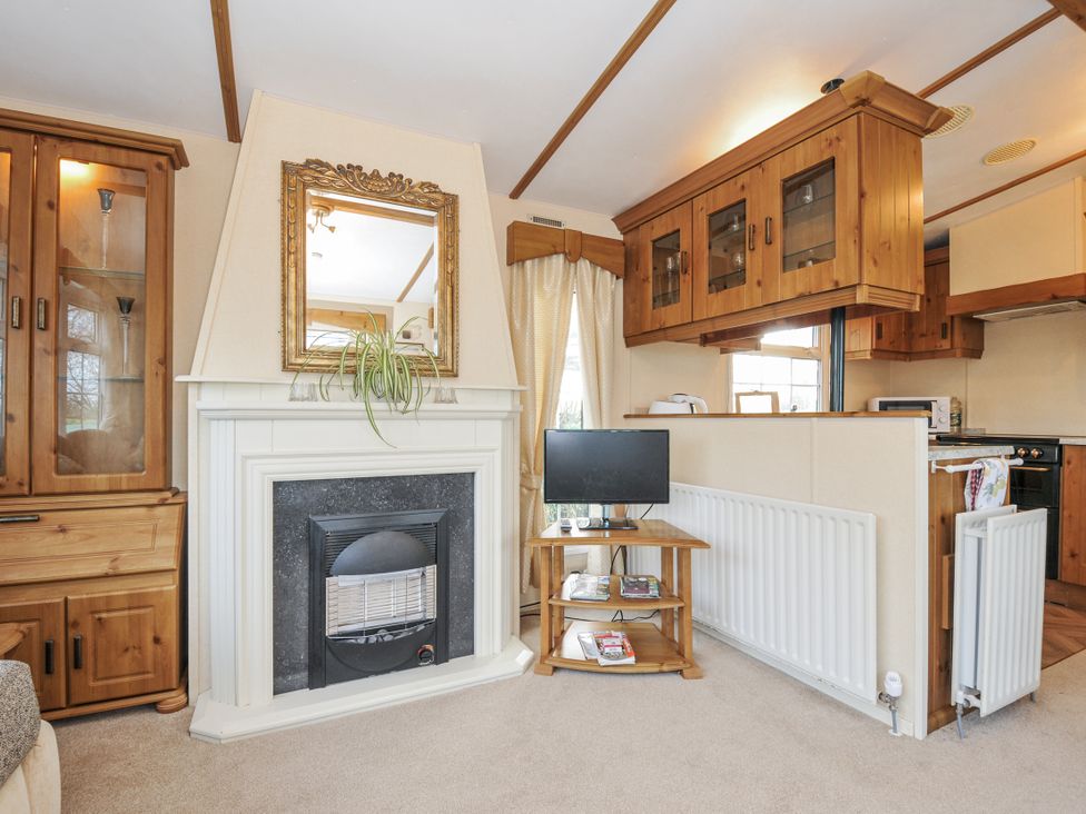A living room with a fireplace and television at Little Malory St Giles-On-The-Heath