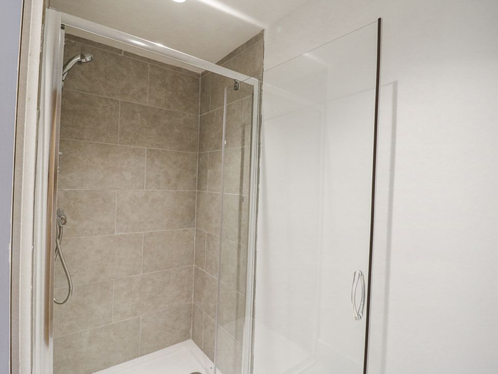 A shower with glass door and tile walls at Little Yeat Farm (4 Bed/4 Bath) in Aylesbury