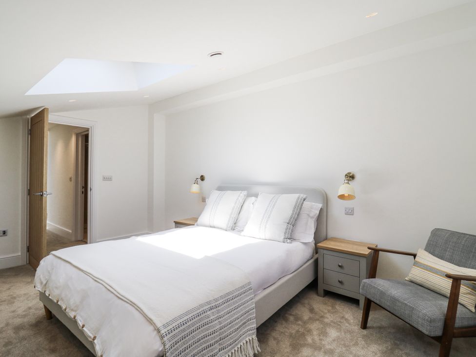 A bedroom with a bed and a chair at Little Yeat Farm (4 Bed/4 Bath) Aylesbury