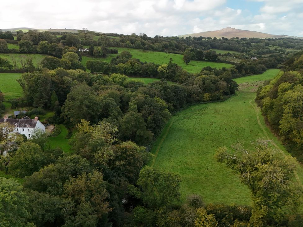 An outdoor view of a house surrounded by trees and fields at Glanduad Fawr Newport, Pembrokeshire