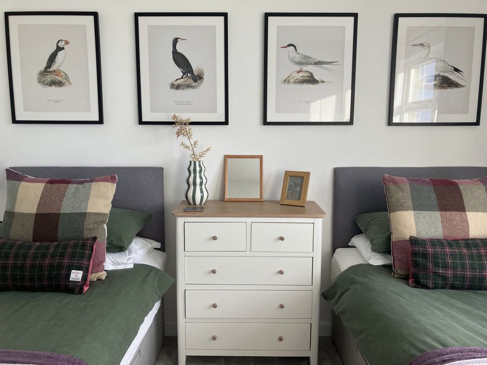 A bedroom with two beds and framed bird prints at Taigh Marsaili, Luskentyre, Isle Of Harris
