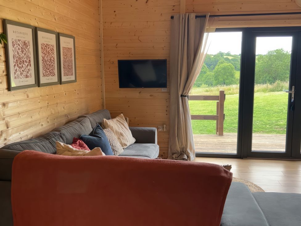 A living room with a sofa and television at Primrose, Higher Wambrook near Chard