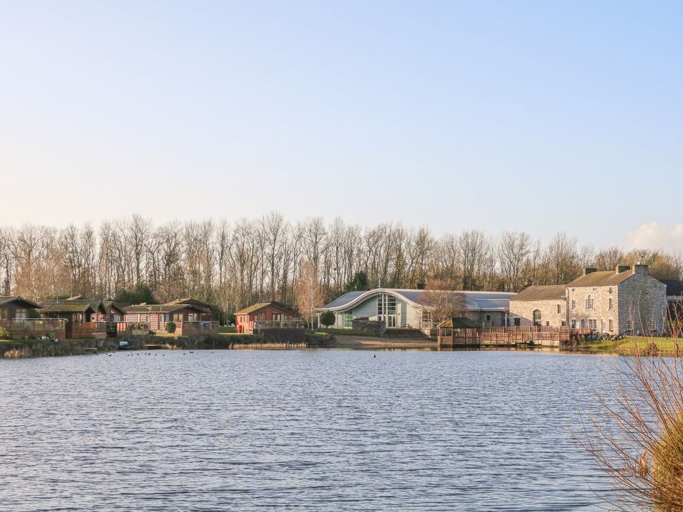 A lakeside view with cottages and a building at Lakeside 12 in Carnforth