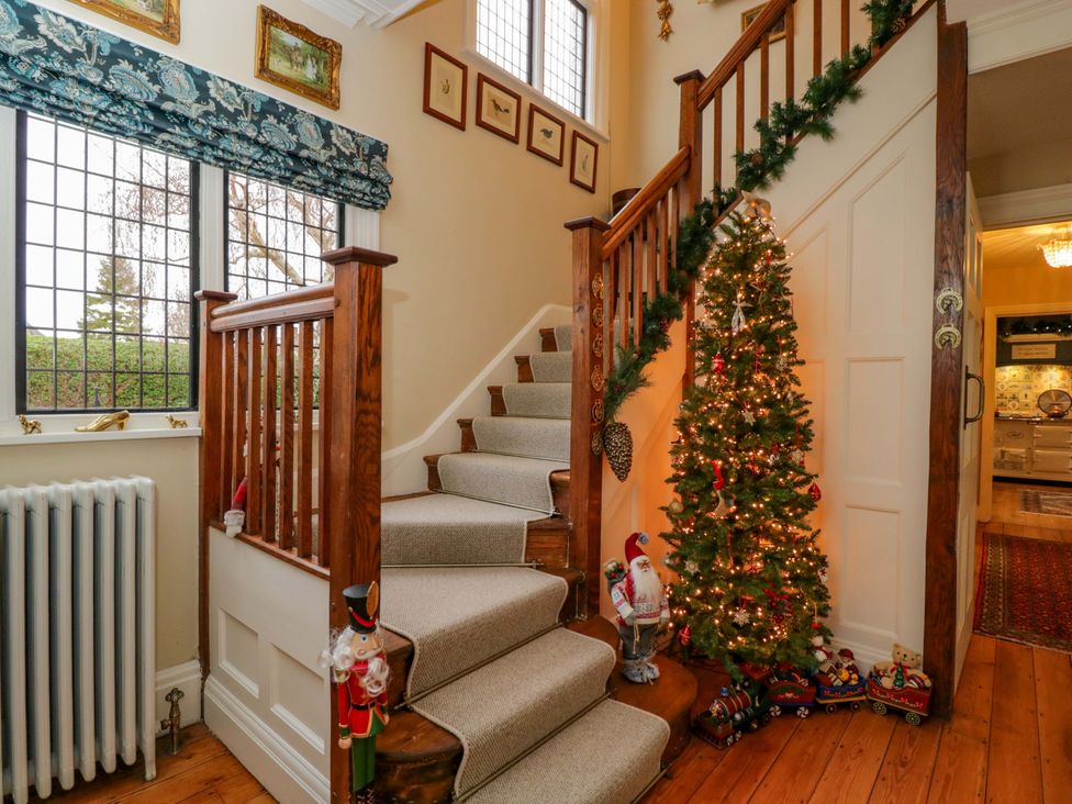 A hallway with a staircase and a Christmas tree at White House in 