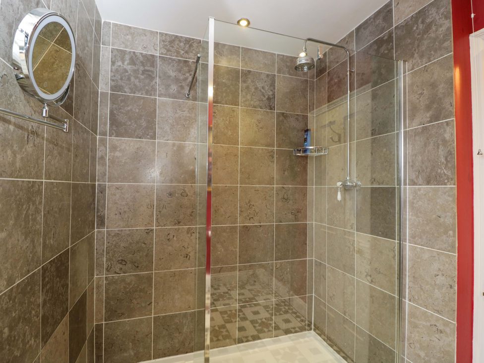 A shower with tiled walls and a mirror at White House