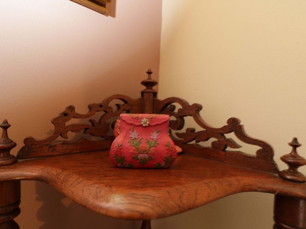 A pink pouch on a wooden shelf at White House