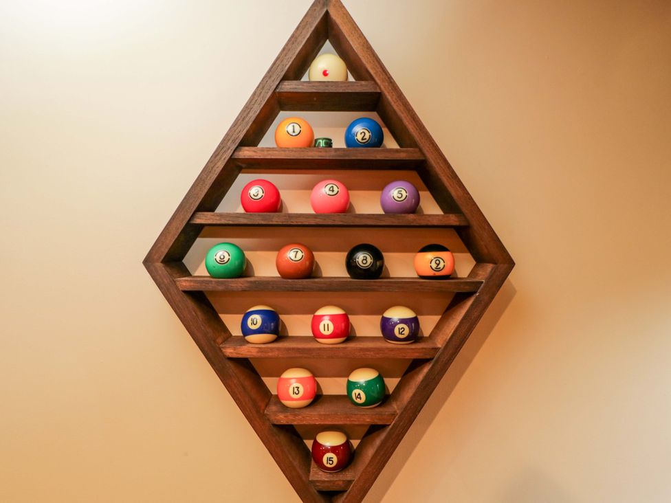 A display of pool balls on a wooden rack in a game room at White House