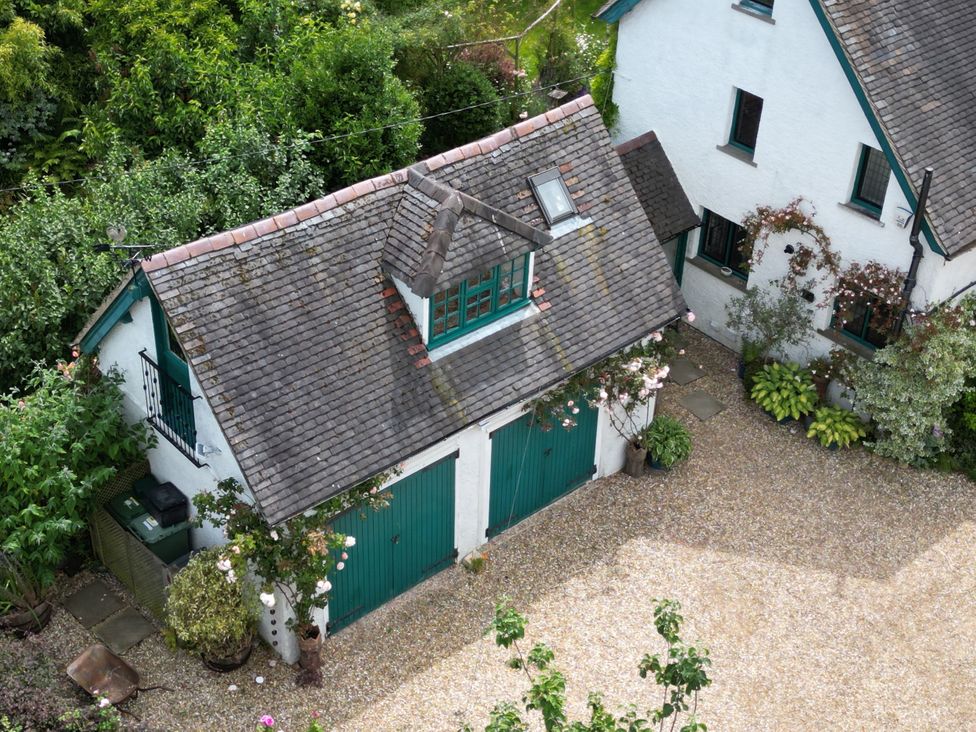 A garage with green doors and gravel driveway at White House in 
