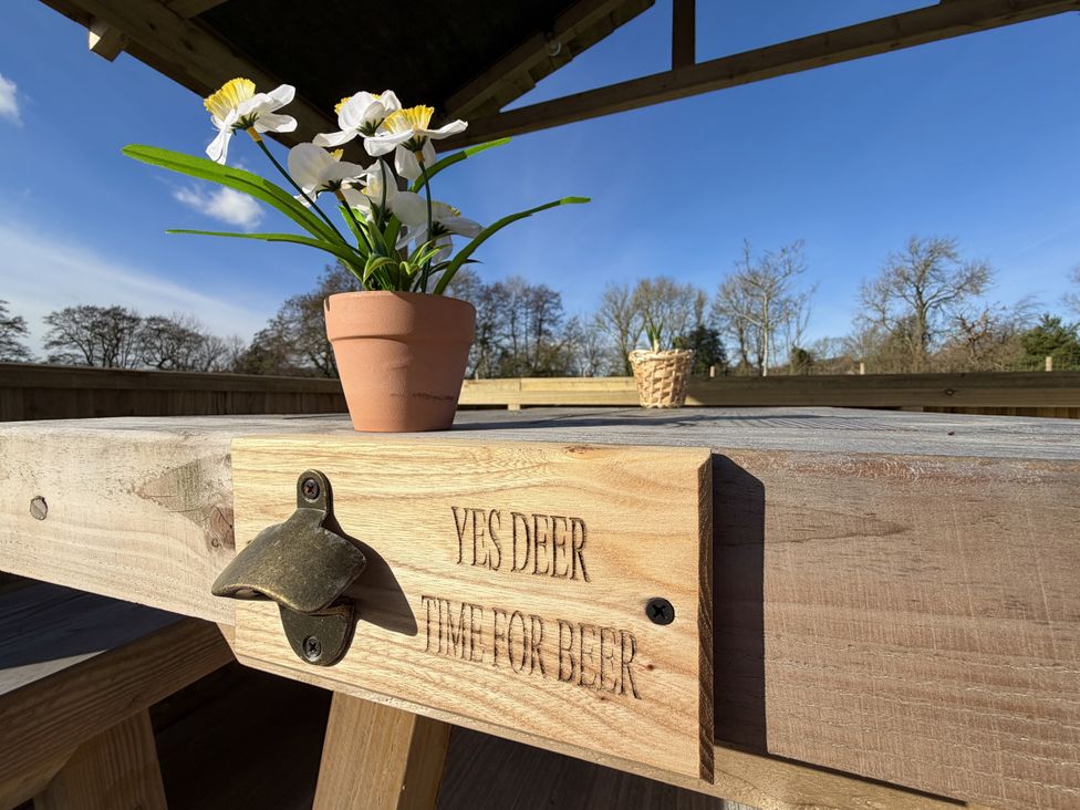 An outdoor seating area with a table and a flower pot at Yes Deer Ashbourne