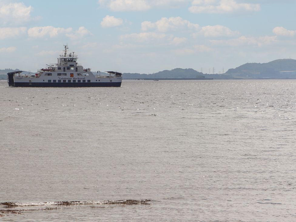 A ferry on water with hills in the background at The Old Rectory in Largs