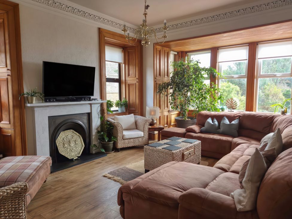 A living room with a television and sofa at The Old Rectory in Largs
