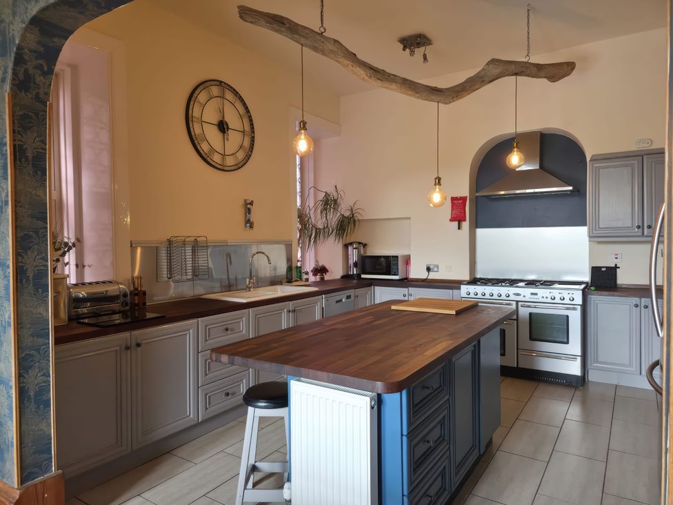 A kitchen with a central island and appliances at The Old Rectory in Largs