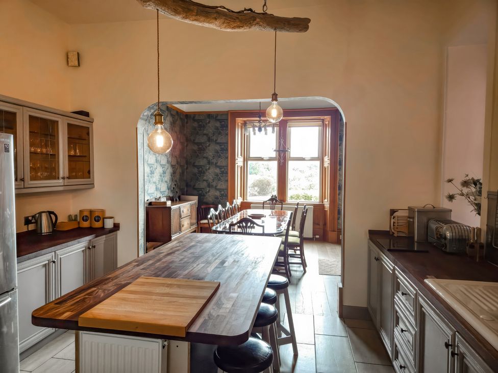 A kitchen with an island and cabinets at The Old Rectory in Largs