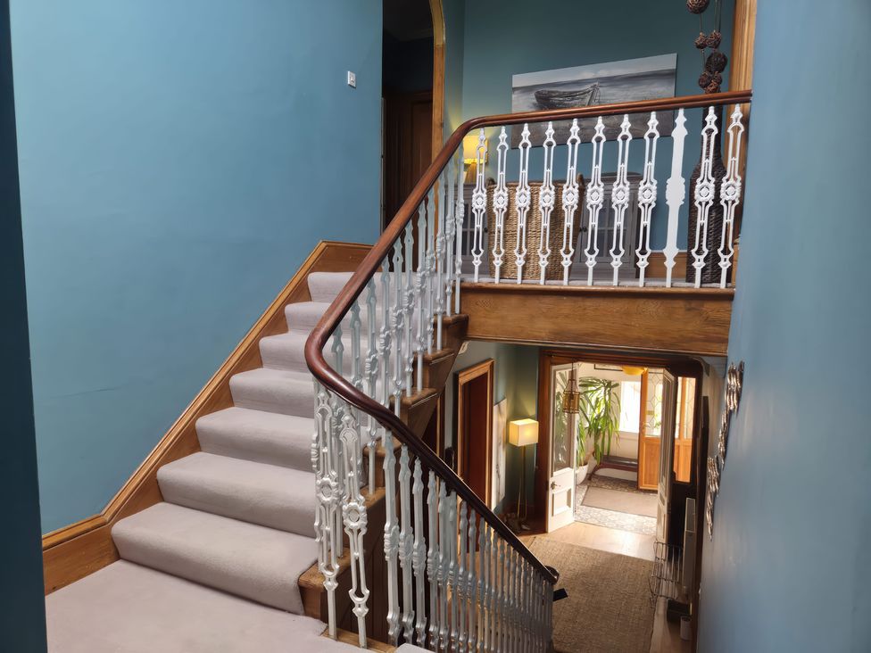 A hallway with a staircase and railing at The Old Rectory in Largs