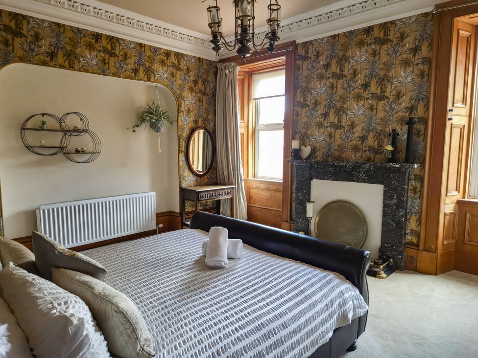 A bedroom with a bed and fireplace at The Old Rectory in Largs