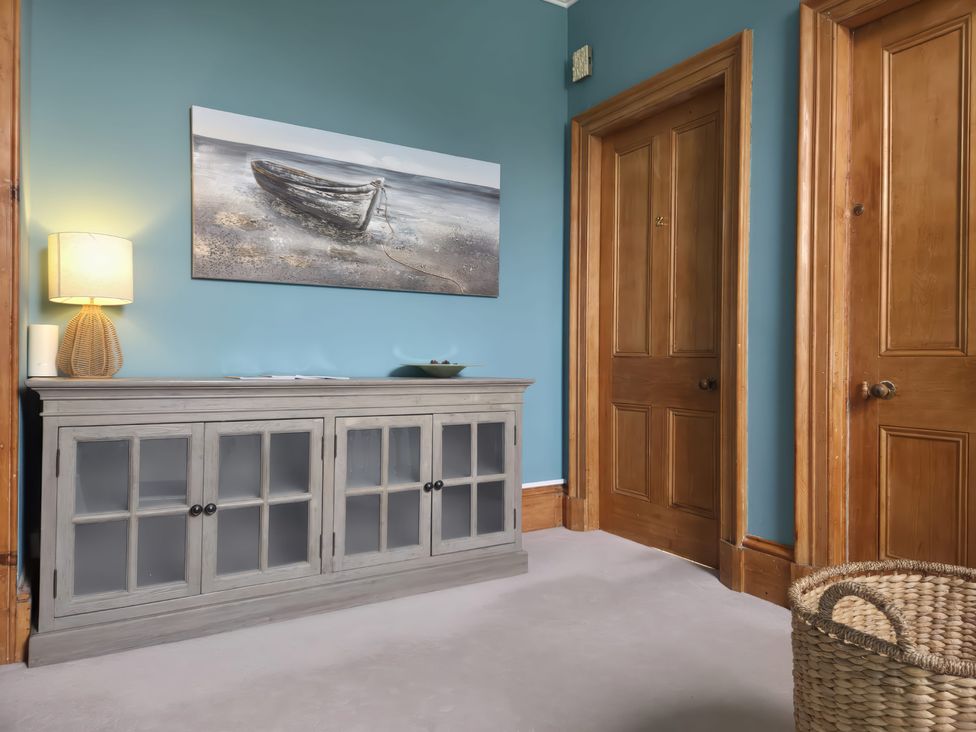 A hallway with a console cabinet and lamp at The Old Rectory in Largs