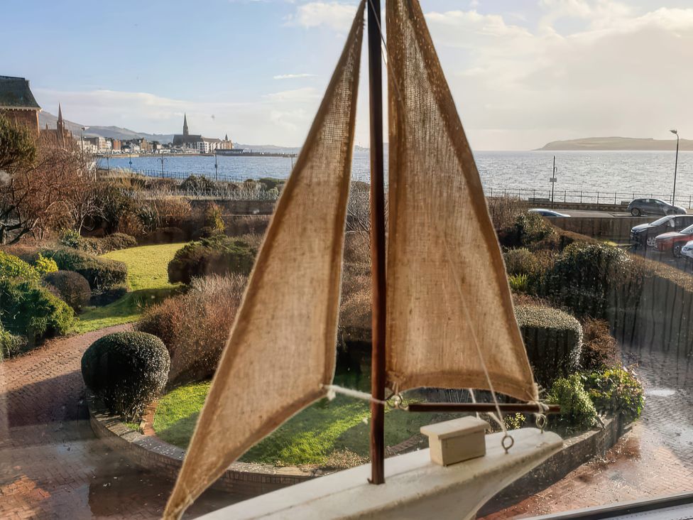 A view of a model sailboat with a seaside and cityscape background at The Old Rectory in Largs