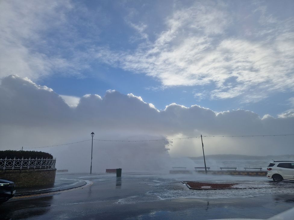 An outdoor view of waves crashing against a shore with clouds at The Old Rectory in Largs