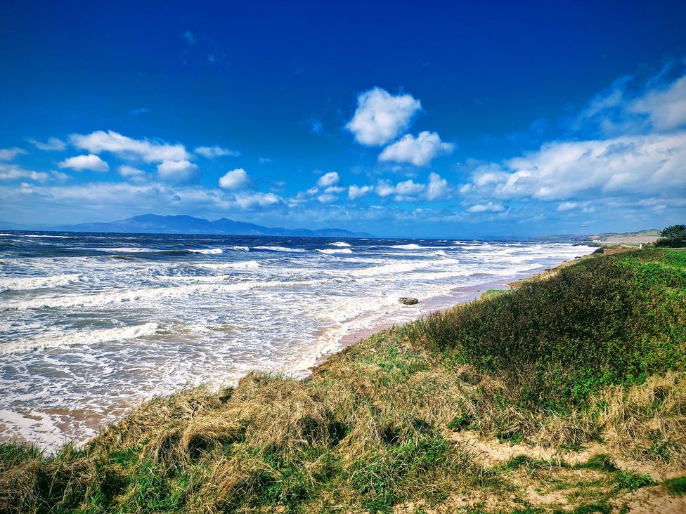 A seashore with ocean waves and grass at The Old Rectory in Largs