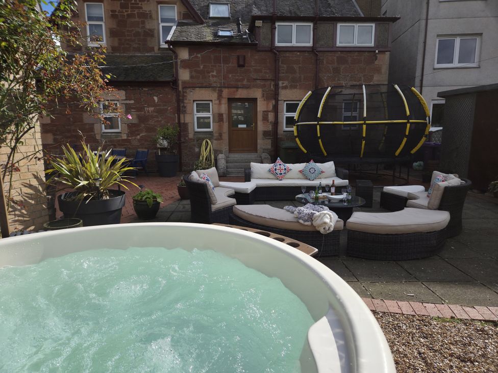 A garden with a hot tub and seating area at The Old Rectory in Largs