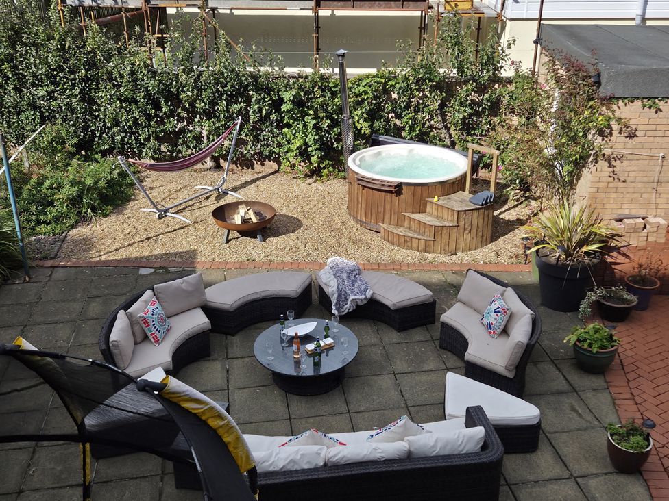A garden with a seating area, hot tub, and fire pit at The Old Rectory in Largs