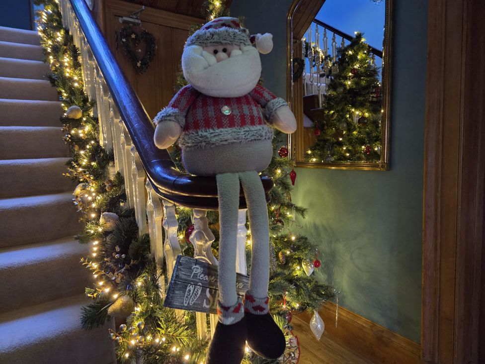 A hallway with a Christmas tree and decorative figure at The Old Rectory in Largs