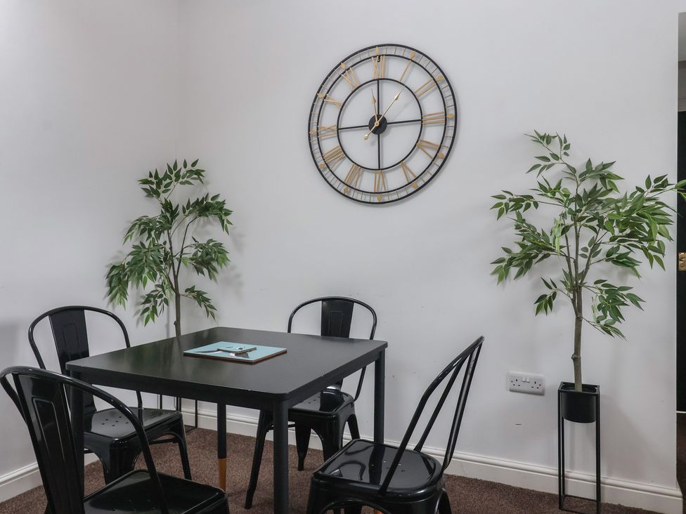 A dining room with a black table and chairs at Gannet in Flamborough