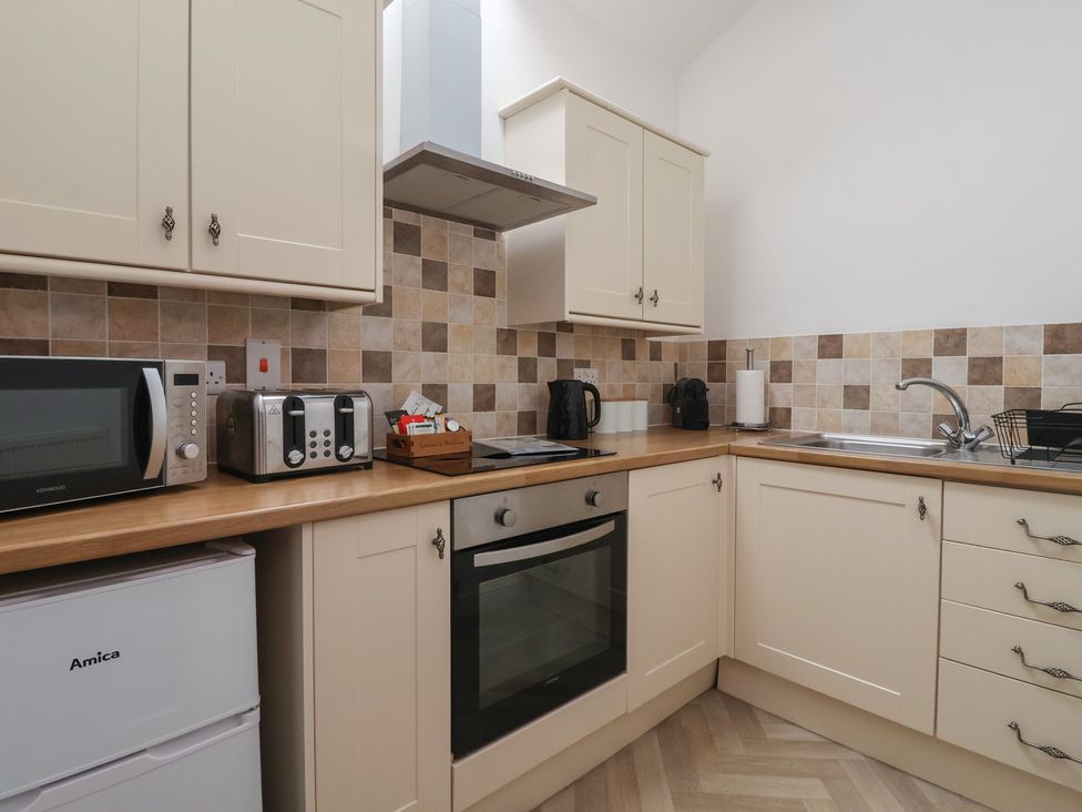 A kitchen with cabinets, appliances and a sink at Gannet in Flamborough