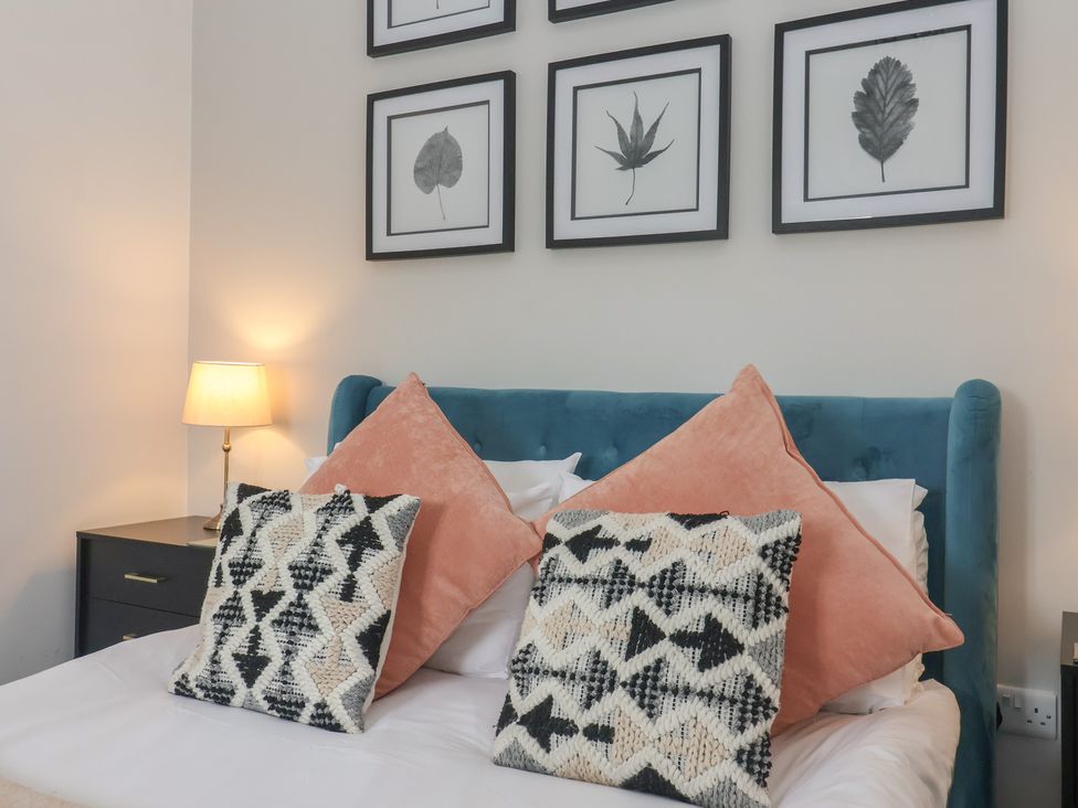 A bedroom with a bed and framed art at Gannet in Flamborough