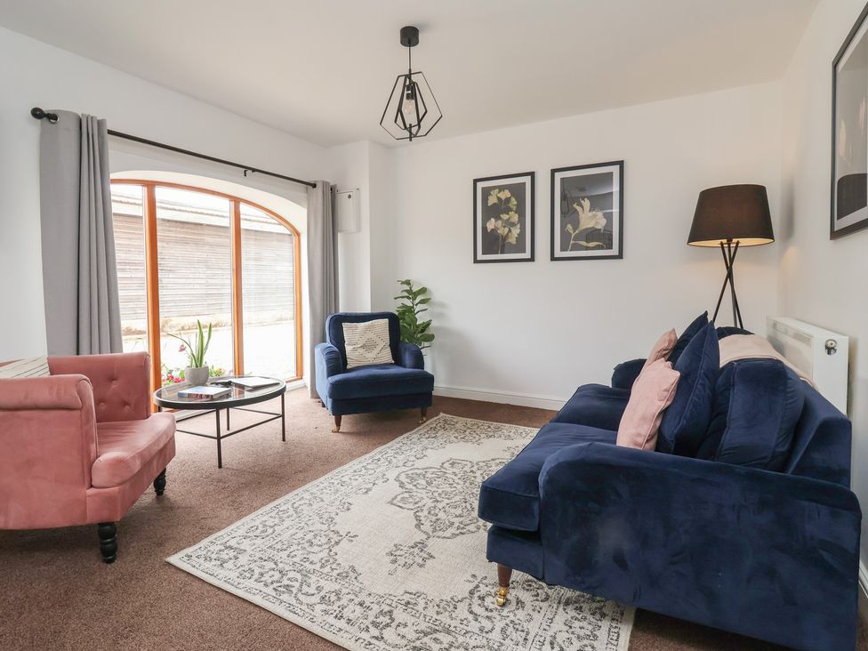 A living room with a sofa, armchair, and coffee table at Razorbill, Flamborough