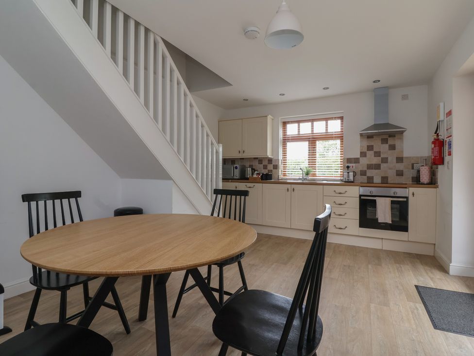 A kitchen with a table and chairs at Razorbill in Flamborough