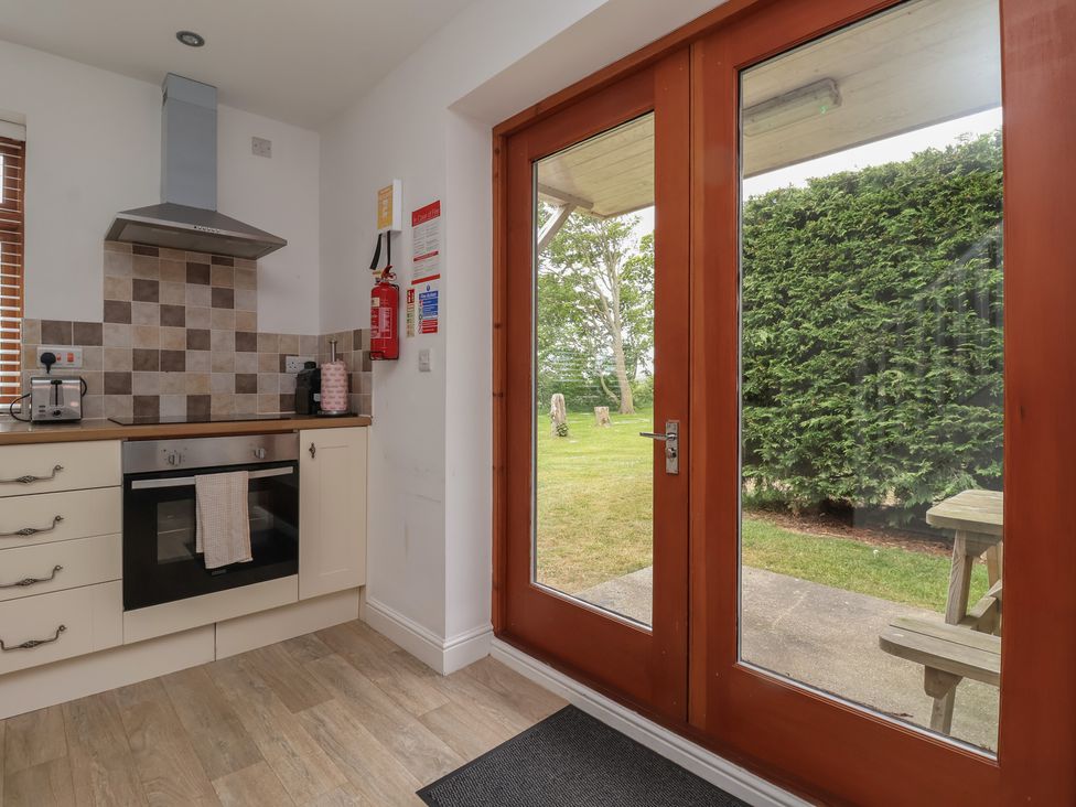 A kitchen with a glass door leading to a garden at Razorbill in Flamborough