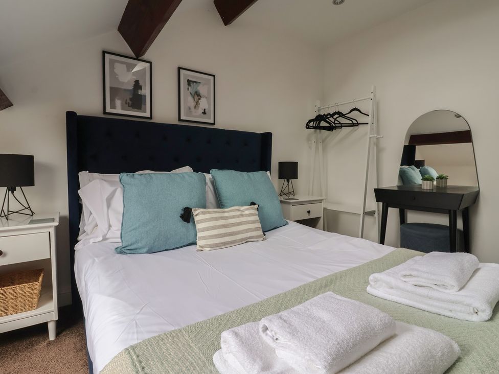 A bedroom with a bed and bedside table at Razorbill in Flamborough