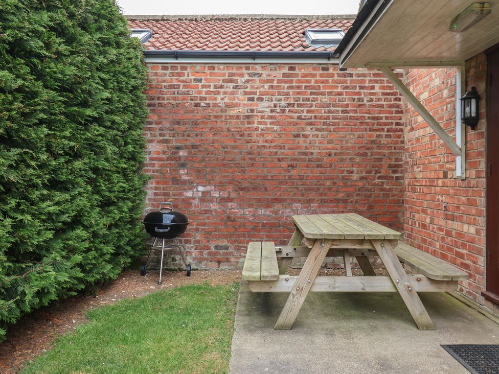An outdoor area with a picnic table and grill at Razorbill in Flamborough