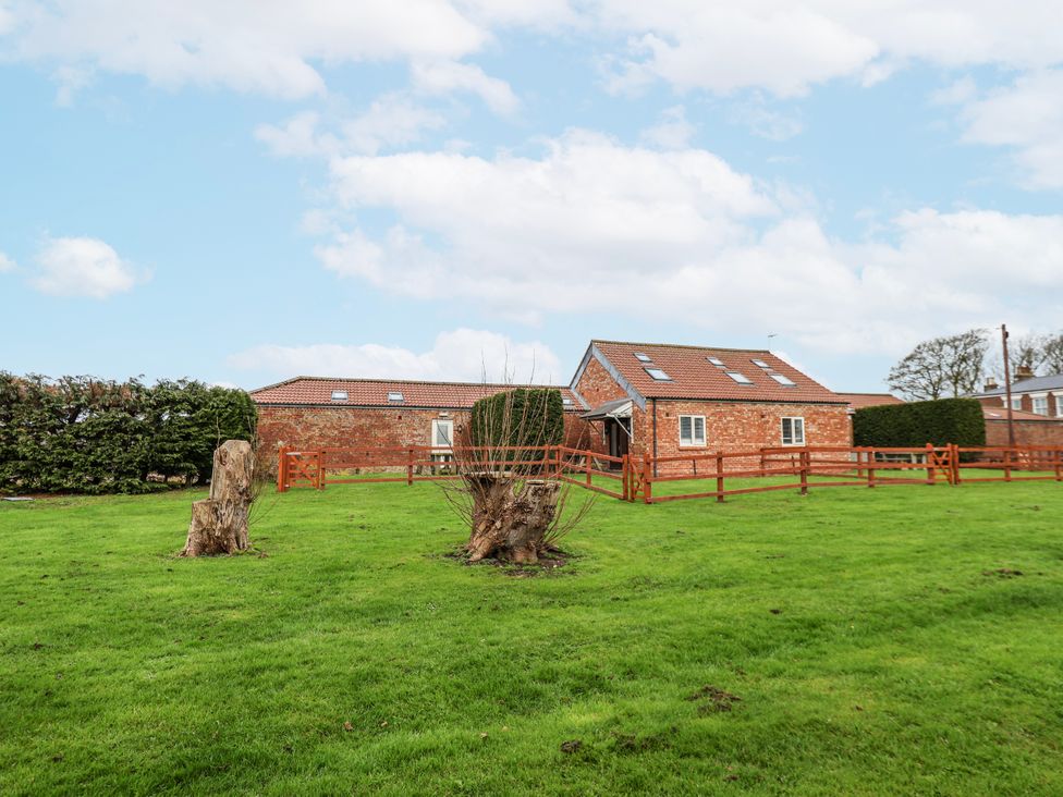 A house with a fence and stumps in the garden at Razorbill in Flamborough