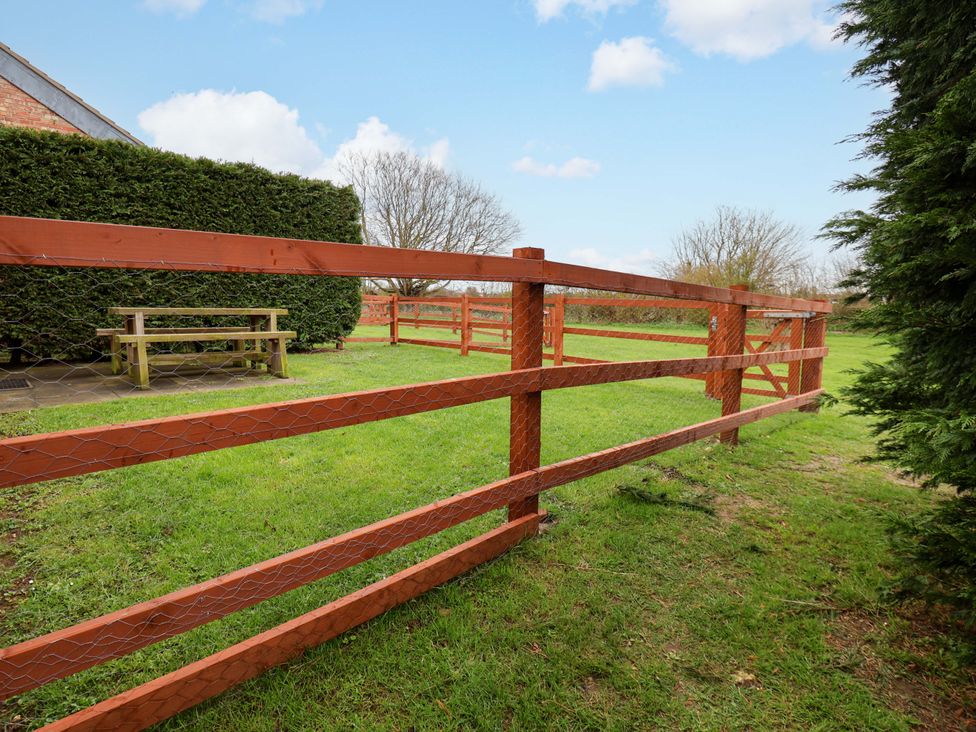 A garden with a wooden fence and a table at Guillemot in Flamborough