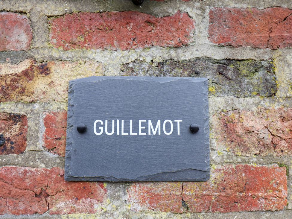 A nameplate with the text Guillemot on a brick wall at Guillemot in Flamborough