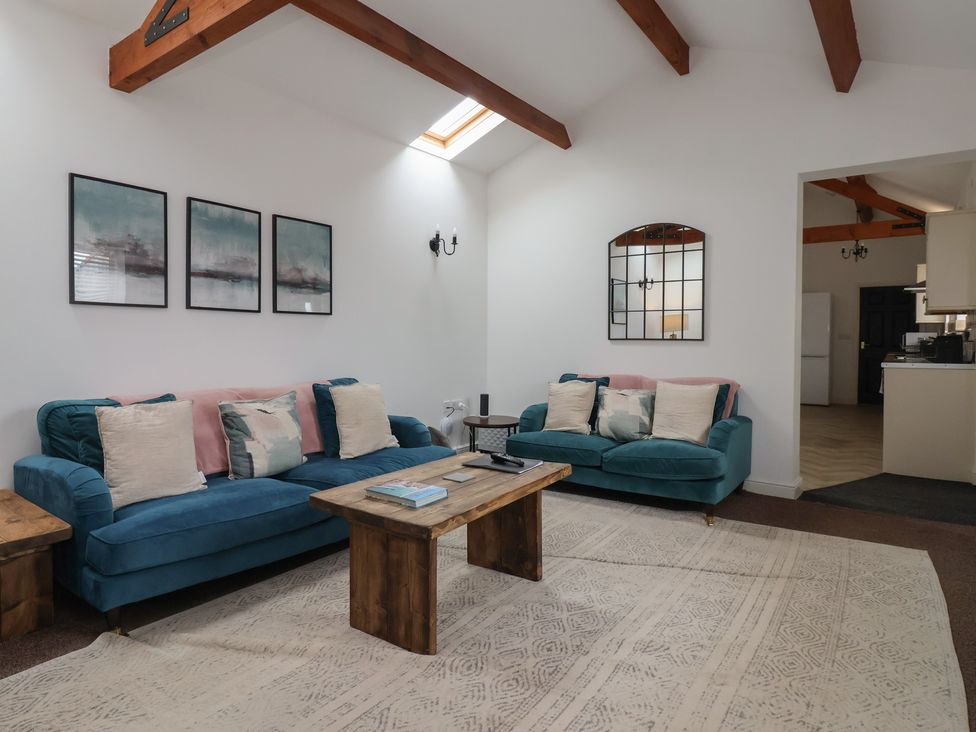 A living room with sofas and a wooden table at Puffin in Flamborough